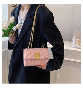 Close-up of pink heart-quilted crossbody bag with a gold rabbit ear metal clasp