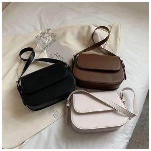 Chic leather crossbody bags in black, coffee, and white on a cream blazer backdrop
