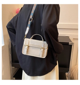 Détail du sac bandoulière vintage avec large sangle brodée et rabat à double boucle