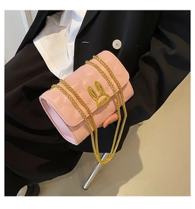 Close-up of pink quilted crossbody bag featuring a golden rabbit buckle and chain strap