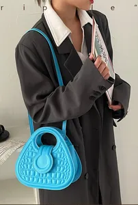 Detail of bright blue croc-embossed handbag held by model in professional attire