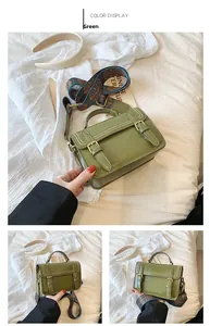 Détail du sac bandoulière vert rétro avec boucles dorées et large sangle bohème