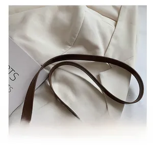 Close-up of brown leather shoulder strap showing smooth edge oil and premium texture