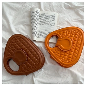 Detail of trendy heart-shaped crocodile pattern handbags in brown and orange colors