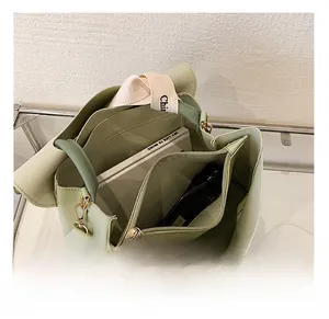 Interior detail of light green leather bag with multi-layer compartments and zipper pocket