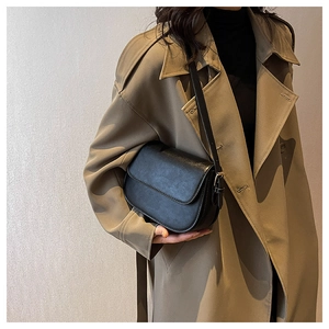 Classic black semi-circle crossbody bag with adjustable strap worn by a model