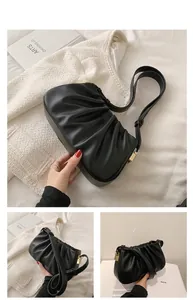 Gros plan sur le sac nuage plissé noir avec boucle carrée dorée et bandoulière réglable