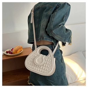 White faux crocodile leather handbag shown worn by a model in a cozy lifestyle setting
