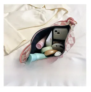Top-down view of pink and white checkered knit bag showing storage for cosmetics and phone