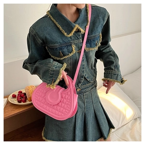 Pink crescent handbag with crocodile texture shown in a casual lifestyle setting