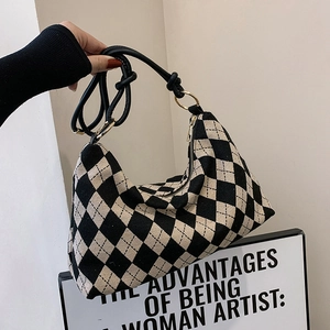 Black and white checkered hobo shoulder bag with a knotted strap and gold hardware accents