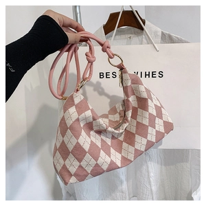 Detailed view of pink and white argyle knit shoulder bag with knotted leather handle