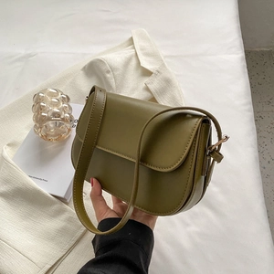 Detailed view of an olive green saddle bag in matte PU leather with gold metal buckle