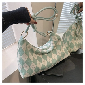 Detail of mint green checkered handbag showing smooth faux leather handle and gold hardware