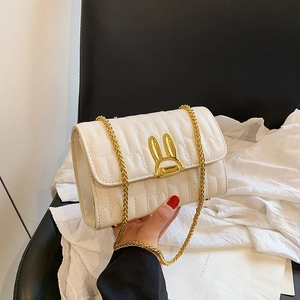 White quilted chain crossbody bag featuring a unique golden bunny ear metal twist lock