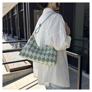 Detail of light green argyle shoulder bag with knot strap detail on white shirt