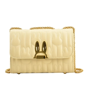 Cream quilted shoulder bag featuring a rabbit ear clasp and golden chain strap