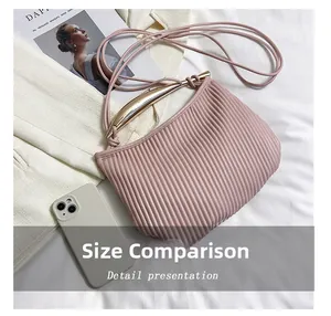 Ruched pale pink crossbody bag size comparison with a smartphone on white blazer