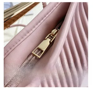 Close-up of pink pleated leather texture and premium gold metal zipper on handbags