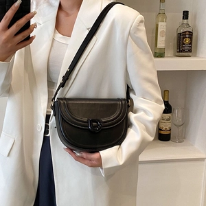 Minimalist black PU leather saddle bag with D-shaped buckle worn with a white blazer
