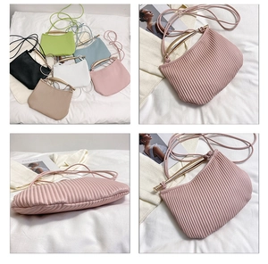 Detailed view of ruched shoulder bag texture with metallic handle and multi-color options