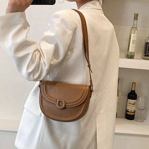 Minimalist brown leather saddle bag for women featuring a retro D-shaped buckle design