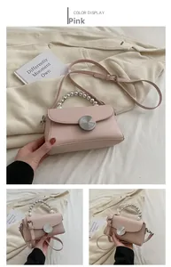 Detail view of pink mini crossbody bag featuring a pearl handle and silver twist lock