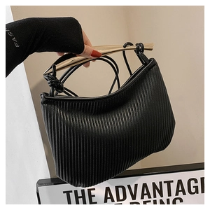 Detailed view of the pleated black leather texture and the golden metal handle of the bag