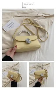 Detail of yellow mini leather crossbody bag with pearl handle and metal lock