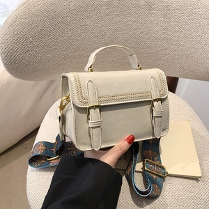 Sac bandoulière rétro crème avec bandoulière ethnique porté par une personne