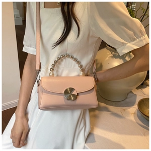 Chic pink mini crossbody bag with pearl handle and golden circular buckle detail