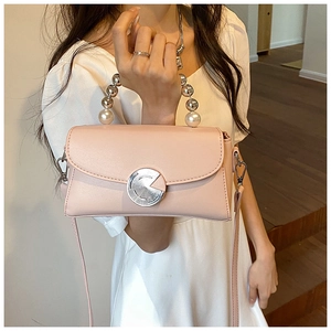 Pink mini crossbody bag featuring pearl handle and textured round metal twist lock