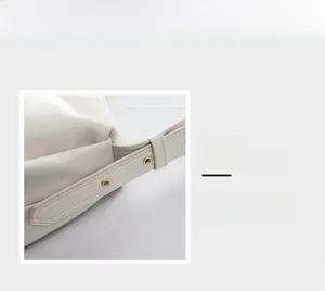 Detail of adjustable white leather strap with gold eyelets and precise stitching