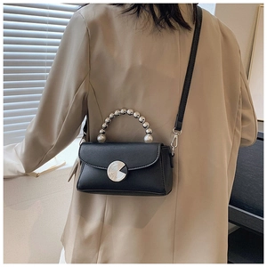 Detail of black mini crossbody bag with pearl handle and silver metallic turn-lock