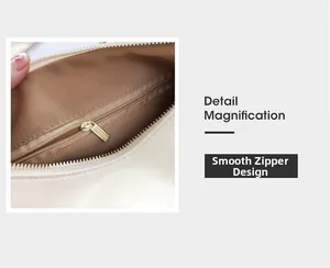 Detail magnification of smooth gold zipper and brown fabric lining on beige handbag