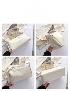Detailed view of cream white minimalist underarm bag with adjustable golden hardware buckles