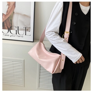Detail of light pink shoulder bag with adjustable strap and golden metal buckle accents