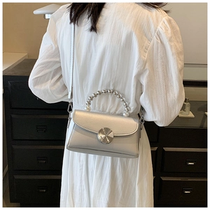 Silver metallic mini crossbody bag with pearl handle and metal clasp detail view