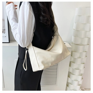 Close-up of cream-colored hobo shoulder bag featuring black adjustable drawstring detail