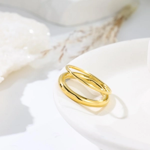 Set of two gold titanium steel minimalist rings on white aesthetic display background
