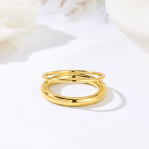 Minimalist polished golden titanium steel chain rings set on elegant white stone background