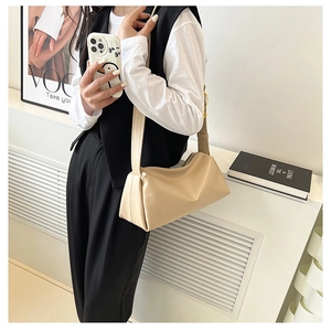 Chic cream white hobo shoulder bag styled on a person with modern minimalist decor