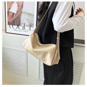 Detail of a beige half-moon shoulder bag with soft PU leather and adjustable wide strap
