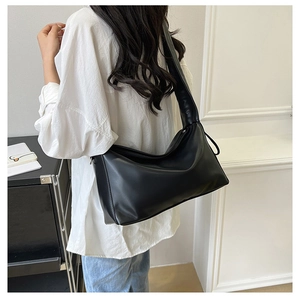 Side view of large black PU leather shoulder bag with wide strap for daily commute