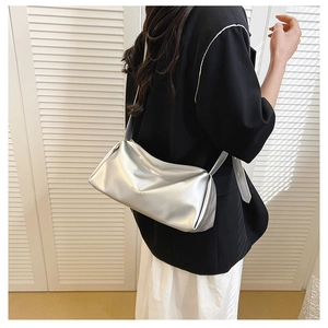 Silver metallic shoulder bag with soft PU leather texture worn by a model in bright light