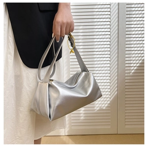 Detail of silver metallic minimalist handbag with dual handles and metal zipper closure