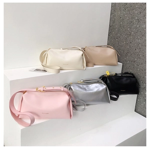Detailed close-up of fashion shoulder bags in multiple colors on minimalist steps
