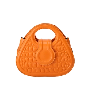 Orange crocodile embossed handbag with unique circular handles and flap closure