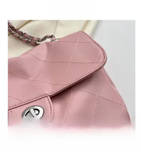 Détail de la texture en cuir matelassé rose et du fermoir rotatif argenté du sac