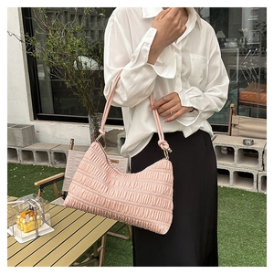 Detailed view of the light pink pleated underarm bag with a woven rope handle